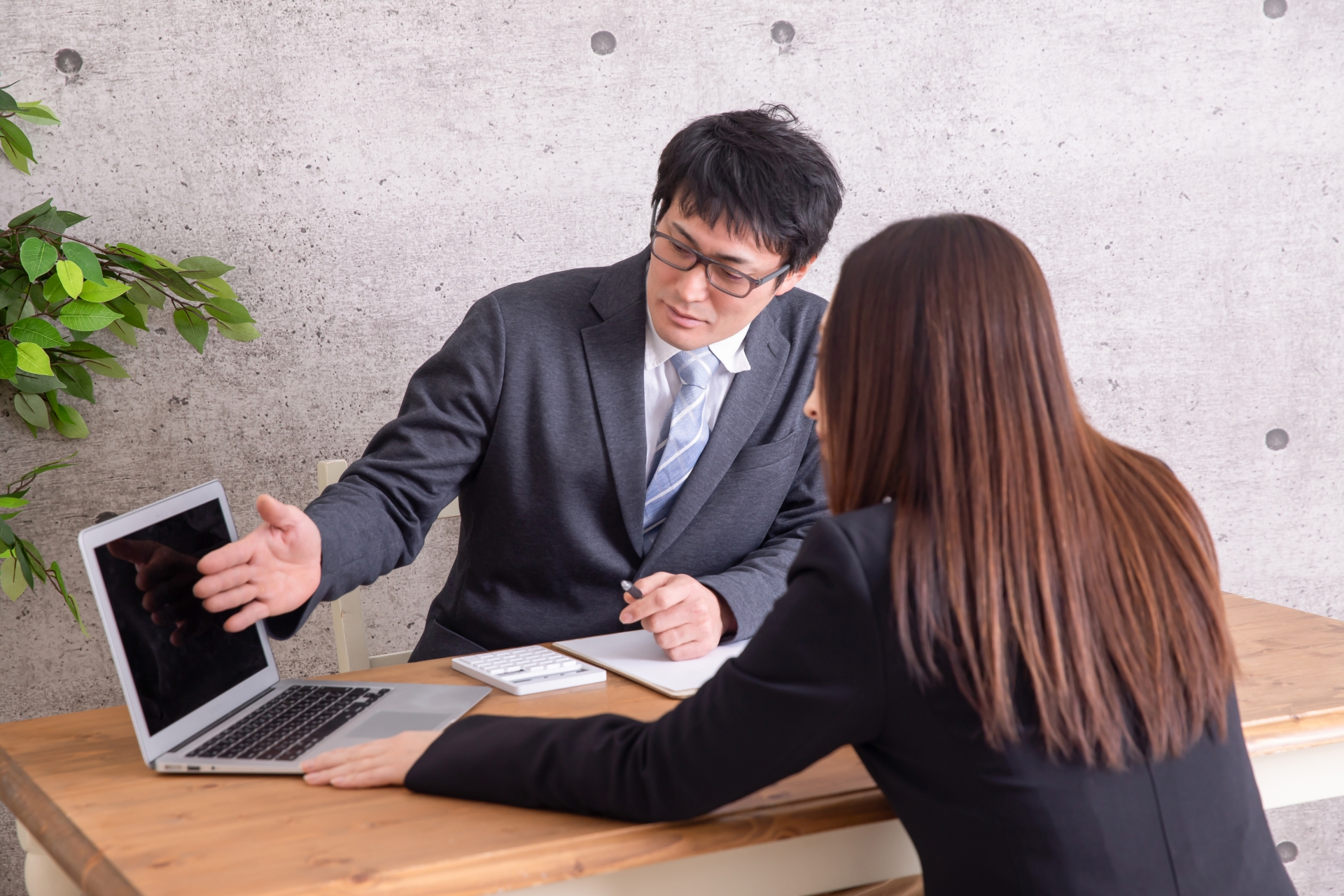 パソコンを見ながら説明を受ける女性